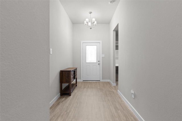119 Comber Rd, Magnolia, TX 77354 - entryway featuring a textured wall, baseboards, light wood-style floors, and a chandelier