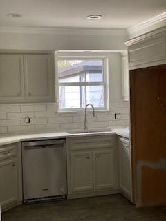 5535 Spellman Rd, Houston, TX 77096 - kitchen with crown molding, a sink, dishwasher, light countertops, and backsplash