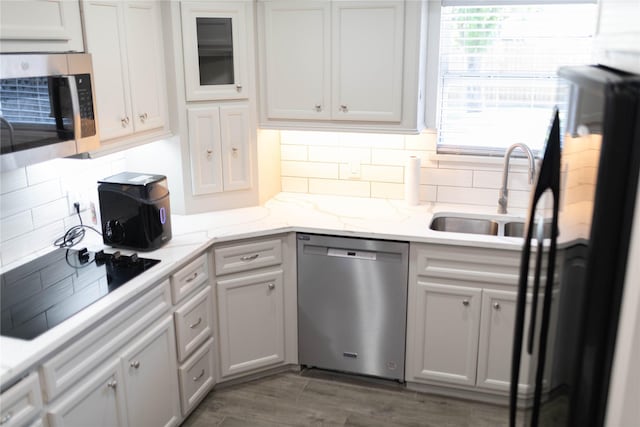 5535 Spellman Rd, Houston, TX 77096 - kitchen with decorative backsplash, a sink, glass insert cabinets, and black appliances