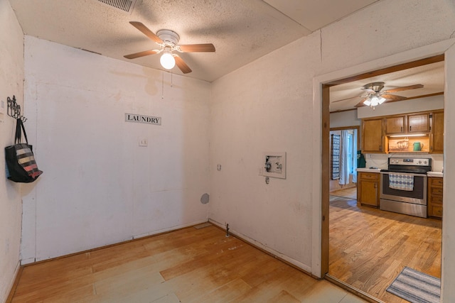 clothes washing area featuring washer hookup, light wood-type flooring, a ceiling fan, and a textured ceiling