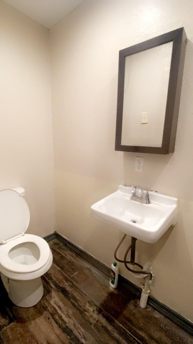 8145 Homewood Ln, Houston, TX 77028 - bathroom featuring toilet, wood finished floors, and a sink