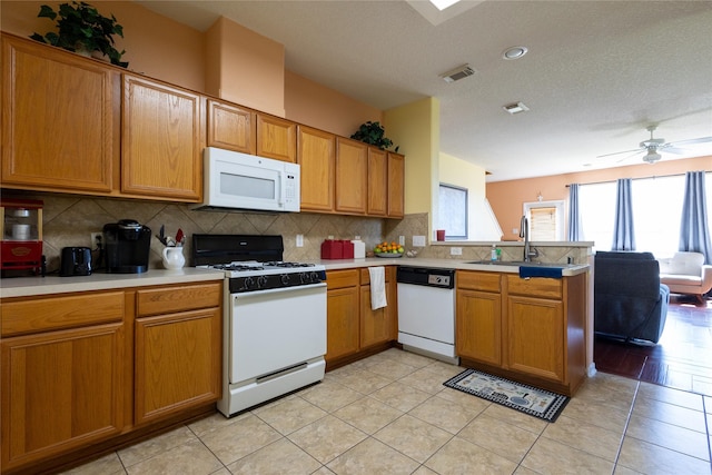 18531 Grove Brook Ln, Cypress, TX 77429 - kitchen featuring white appliances, a peninsula, a sink, light countertops, and decorative backsplash