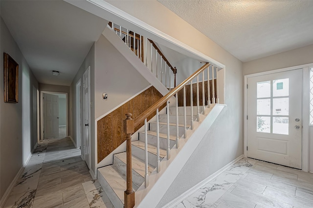 811 Loire Ln, Houston, TX 77090 - foyer featuring marble finish floor, baseboards, and stairway