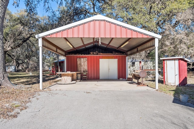 1473 County Road 411, Uvalde, TX 78801 - view of parking featuring a storage unit, a carport, and asphalt driveway