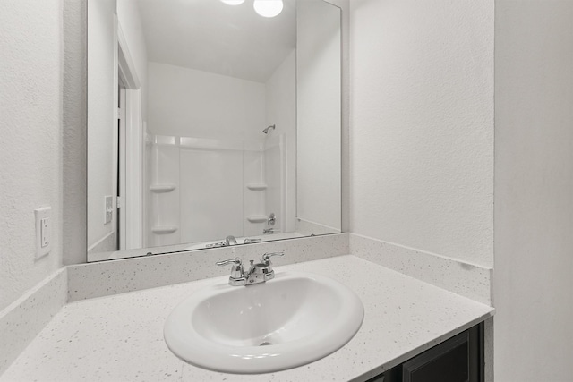 bathroom featuring a shower and vanity