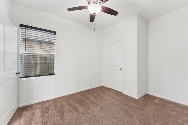unfurnished room featuring baseboards, a ceiling fan, and carpet