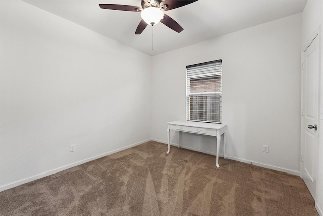 carpeted spare room featuring baseboards and ceiling fan