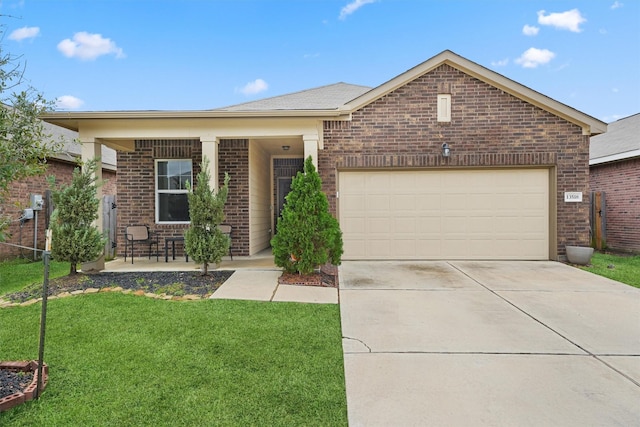 single story home featuring concrete driveway, a front yard, brick siding, a porch, and a garage