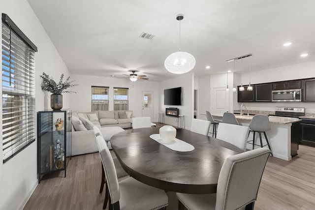 dining space featuring ceiling fan with notable chandelier, visible vents, light wood-style flooring, and recessed lighting