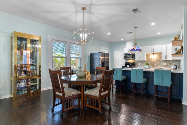 2102 Avenue N Ave N, Galveston, TX 77550 - dining space featuring dark wood-style floors, visible vents, baseboards, and an inviting chandelier