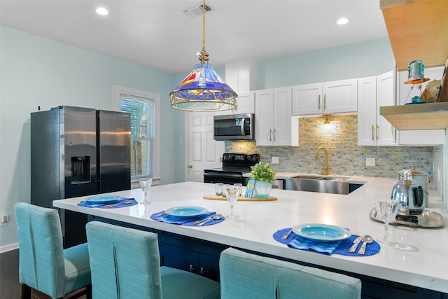 2102 Avenue N Ave N, Galveston, TX 77550 - kitchen with light countertops, a sink, appliances with stainless steel finishes, visible vents, and decorative light fixtures