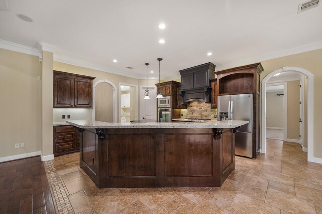 33922 High Point Dr, Magnolia, TX 77355 - kitchen featuring stainless steel appliances, arched walkways, dark brown cabinets, crown molding, and recessed lighting