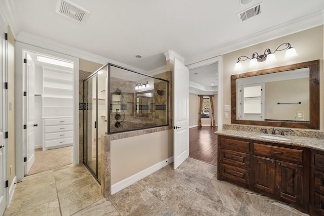 33922 High Point Dr, Magnolia, TX 77355 - bathroom featuring ornamental molding, vanity, a stall shower, and a walk in closet