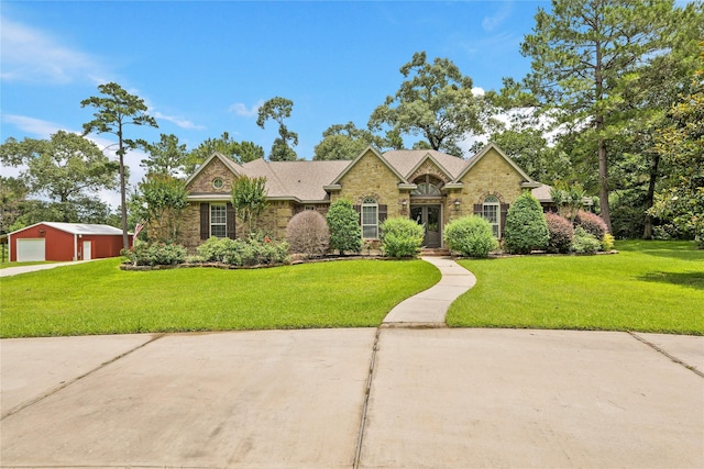33922 High Point Dr, Magnolia, TX 77355 - traditional-style home with an outdoor structure, a front yard, a garage, stone siding, and brick siding