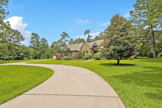 33922 High Point Dr, Magnolia, TX 77355 - view of front of house with a front lawn, curved driveway, and stone siding