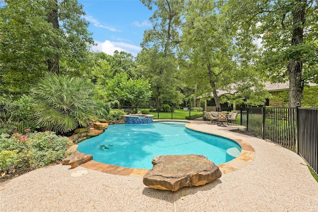 33922 High Point Dr, Magnolia, TX 77355 - view of swimming pool with a fenced backyard, a patio, a pool with connected hot tub, and view of scattered trees