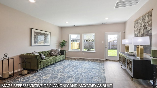 living area featuring visible vents, baseboards, and wood finished floors