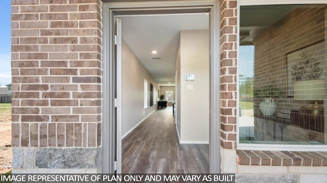 doorway to property with brick siding