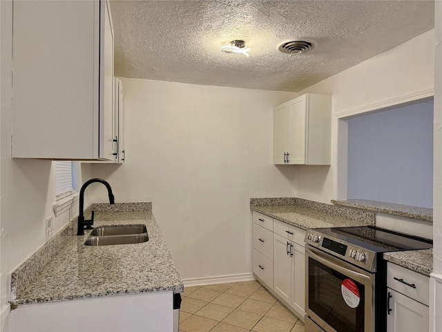 kitchen featuring a sink, stainless steel electric range, white cabinets, baseboards, and visible vents