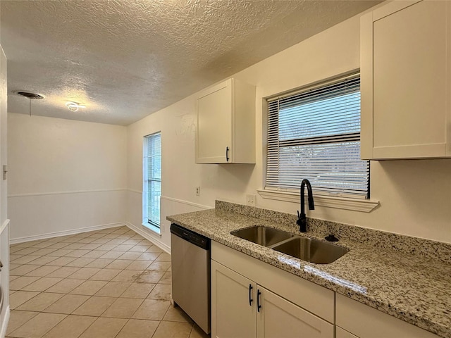kitchen with dishwasher, visible vents, light tile patterned floors, a sink, and a textured ceiling