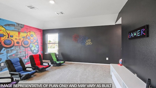 living area featuring a textured wall, carpet, visible vents, and baseboards