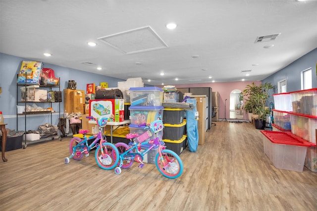 1725 Strawn Rd, Houston, TX 77039 - playroom with light wood-style flooring, recessed lighting, arched walkways, and attic access