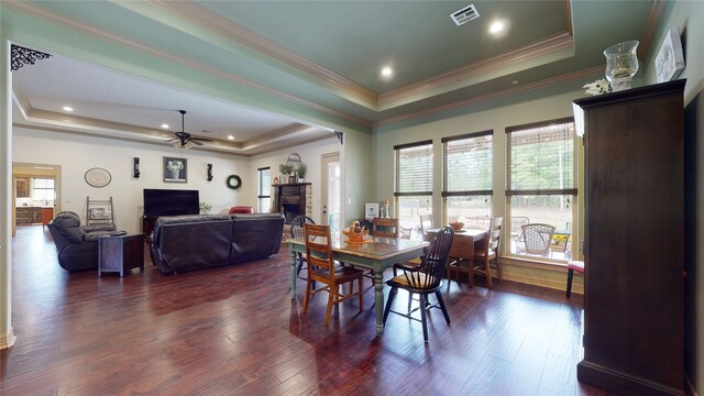 dining space featuring plenty of natural light, a fireplace, visible vents, and a raised ceiling
