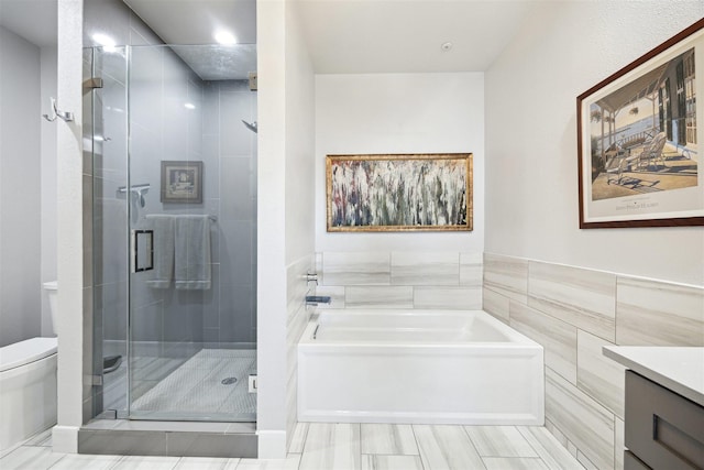 3333 Allen Pkwy Unit 701, Houston, TX 77019 - bathroom featuring toilet, a bath, vanity, a stall shower, and tile walls