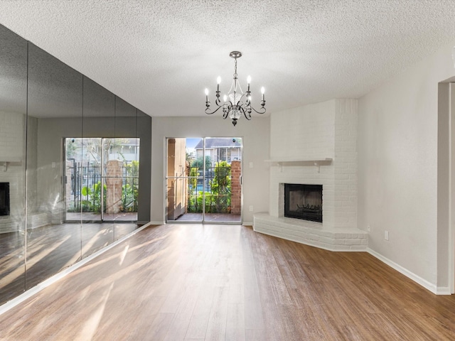 2800 Jeanetta St Unit 2803, Houston, TX 77063 - unfurnished living room featuring an inviting chandelier, a textured ceiling, wood finished floors, and a fireplace