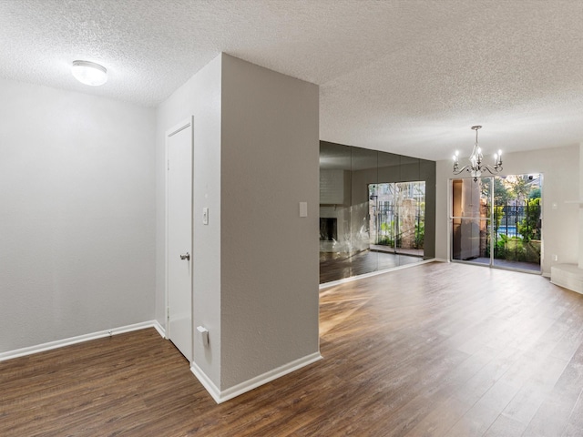 2800 Jeanetta St Unit 2803, Houston, TX 77063 - unfurnished dining area with baseboards, a textured ceiling, wood finished floors, and a notable chandelier