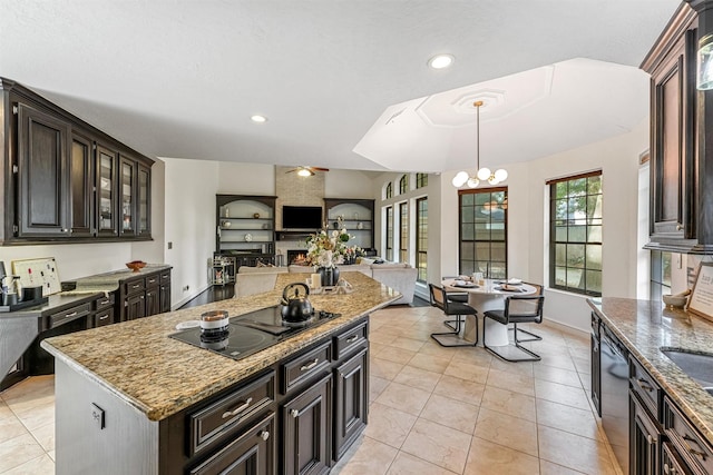 kitchen featuring light stone counters, light tile patterned floors, glass insert cabinets, and black appliances
