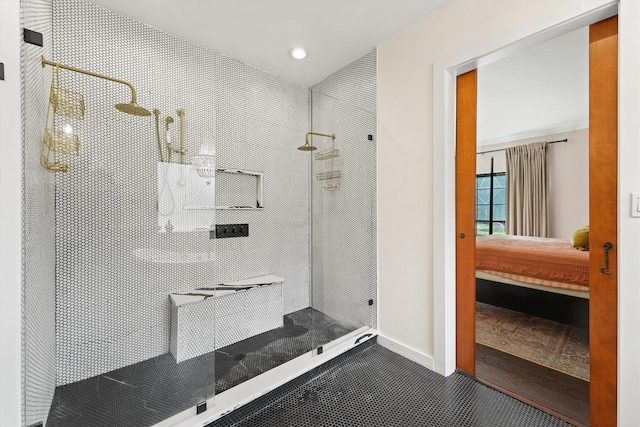 full bath featuring baseboards, connected bathroom, and walk in shower