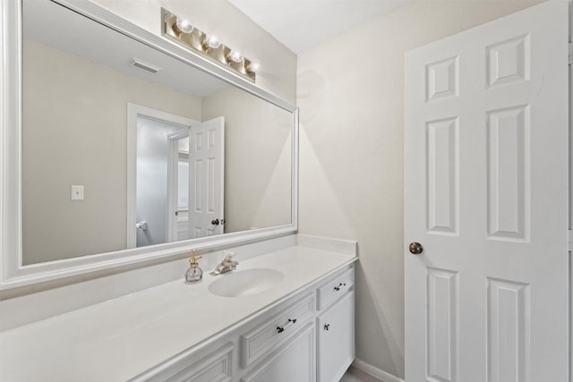 bathroom featuring vanity, baseboards, and visible vents