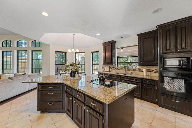 kitchen with light tile patterned floors, black appliances, a chandelier, a sink, and hanging light fixtures