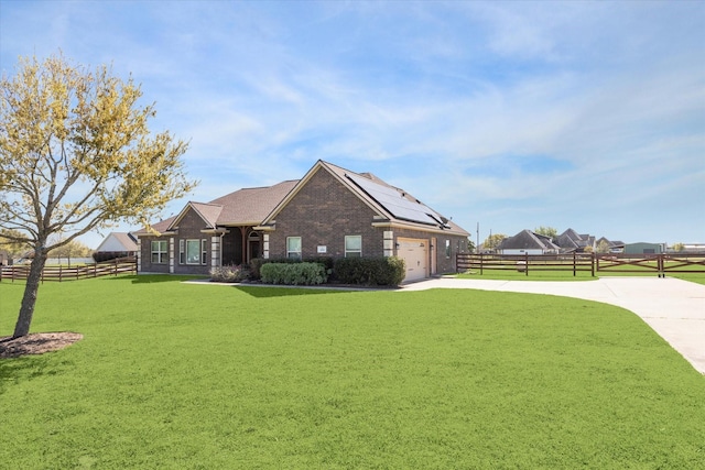 2688 Settlers Way Dr, Sealy, TX 77474 - view of front facade with concrete driveway, fence, a front lawn, brick siding, and roof mounted solar panels