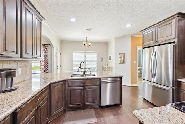 2688 Settlers Way Dr, Sealy, TX 77474 - kitchen with a sink, appliances with stainless steel finishes, a peninsula, dark wood finished floors, and decorative backsplash