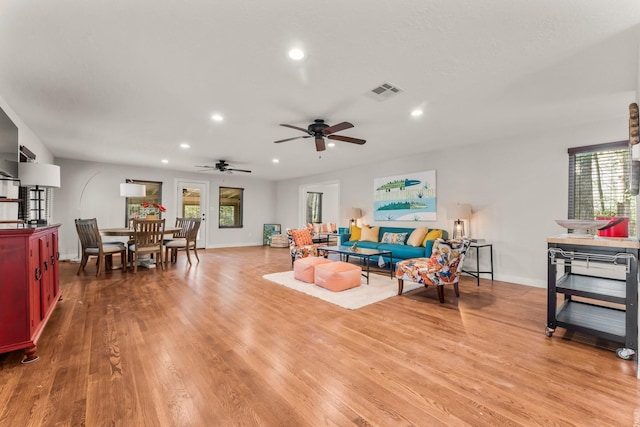 living room with visible vents, baseboards, wood finished floors, recessed lighting, and a ceiling fan