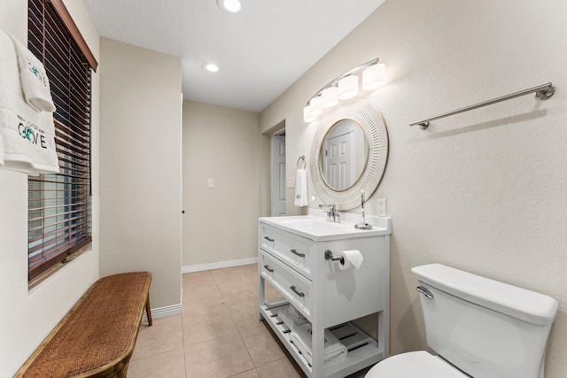 bathroom featuring baseboards, toilet, tile patterned floors, recessed lighting, and vanity