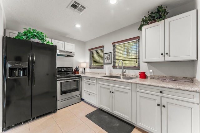 kitchen with stainless steel range with electric stovetop, black fridge with ice dispenser, visible vents, under cabinet range hood, and a sink