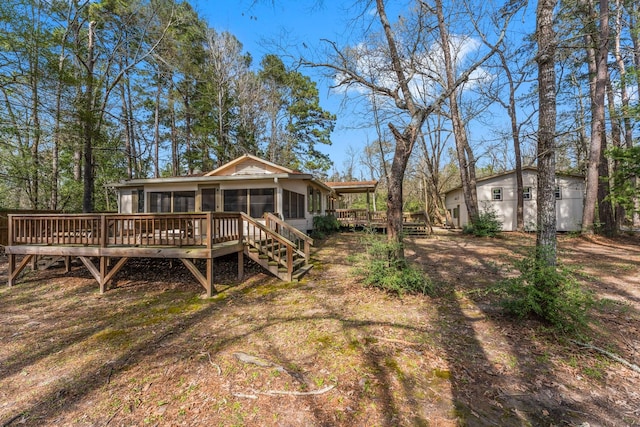 rear view of house featuring a wooden deck and a sunroom