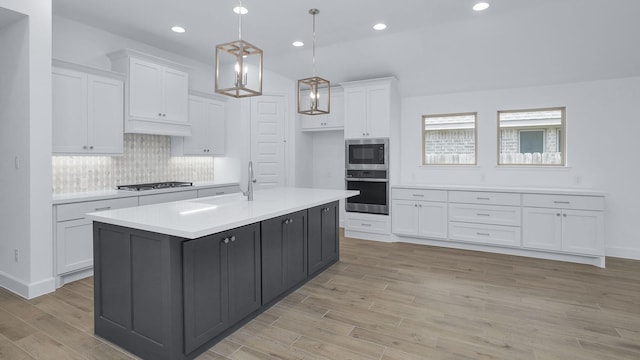 19415 Sorrel Stallion Trl, Tomball, TX 77377 - kitchen with appliances with stainless steel finishes, white cabinets, light countertops, light wood finished floors, and backsplash