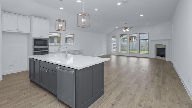 19415 Sorrel Stallion Trl, Tomball, TX 77377 - kitchen featuring appliances with stainless steel finishes, gray cabinetry, white cabinets, a ceiling fan, and light wood-style flooring