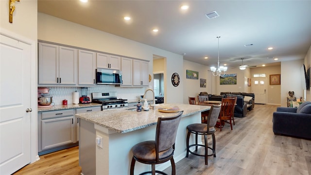 21586 Jordan Pond Rdg, Porter, TX 77365 - kitchen with stainless steel appliances, gray cabinetry, a sink, open floor plan, and recessed lighting