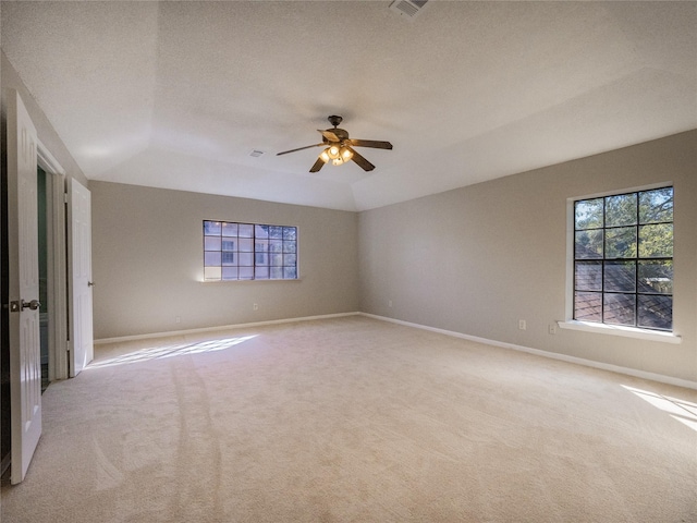 spare room with light carpet, a ceiling fan, and baseboards