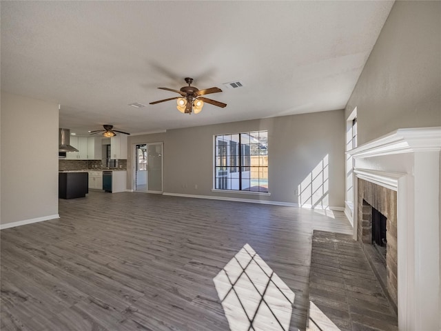 unfurnished living room with ceiling fan, baseboards, dark wood-type flooring, and visible vents