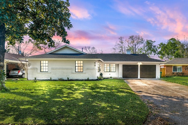 ranch-style home with a lawn, driveway, a garage, and brick siding