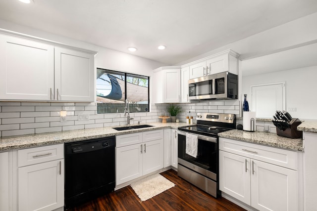 kitchen with a sink, white cabinetry, tasteful backsplash, stainless steel appliances, and dark wood-type flooring