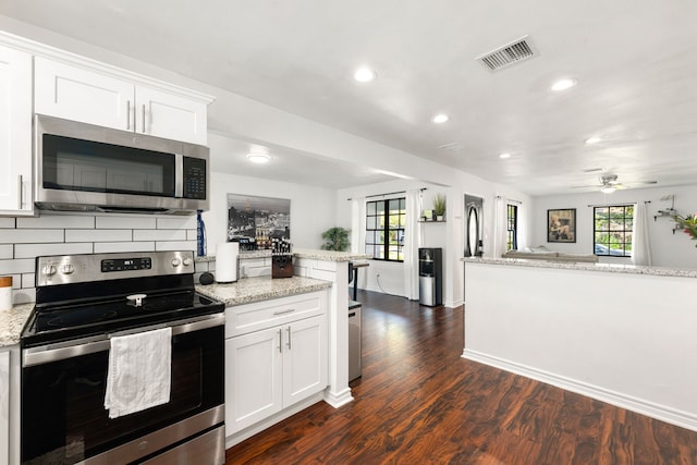 kitchen featuring decorative backsplash, dark wood-style flooring, visible vents, stainless steel appliances, and white cabinetry