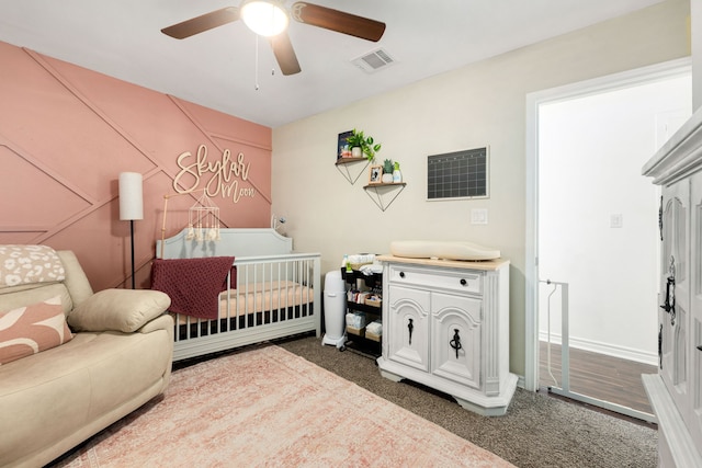 bedroom featuring a ceiling fan, dark carpet, and visible vents