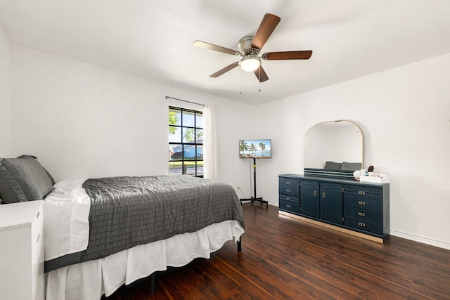 bedroom featuring baseboards, ceiling fan, and dark wood-type flooring